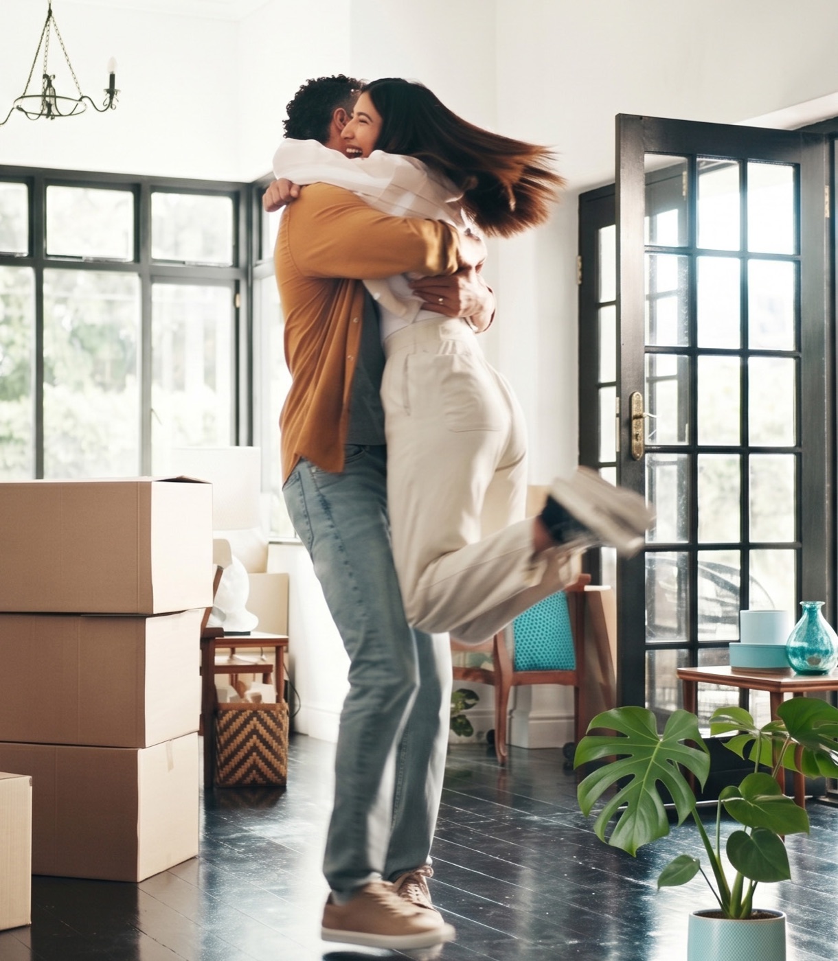 A couple celebrating in their new home among moving boxes